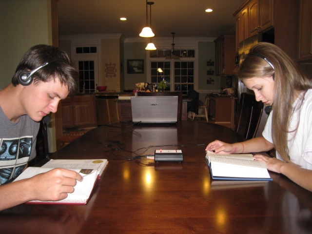 Two people sitting at a table with books